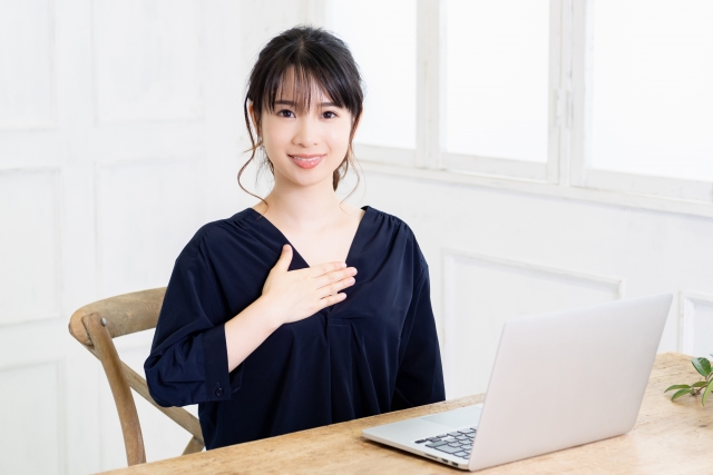 胸に手を当てる女性の画像